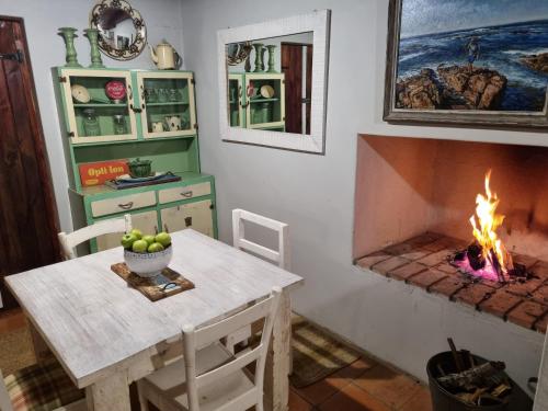 a dining room with a table and a fireplace at StarFish Accommodation in Struisbaai
