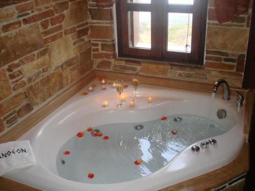 La salle de bains est pourvue d'une baignoire avec des bougies. dans l'établissement Luxury Guesthouse Pantheon, à Palaios Panteleimonas