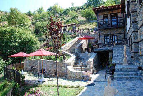 a building with a staircase leading to a building with red umbrellas at Luxury Guesthouse Pantheon in Palaios Panteleimon