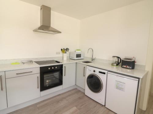 a kitchen with a washing machine and a microwave at Coolnaharragill Lower Annexe in Killarney
