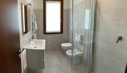 uma casa de banho com um WC, um lavatório e um chuveiro em LOCANDA L'OFFICINA em Ceggia