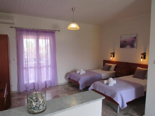 een hotelkamer met twee bedden en een raam bij Biscoutsis Apartments & Studios in Kavos
