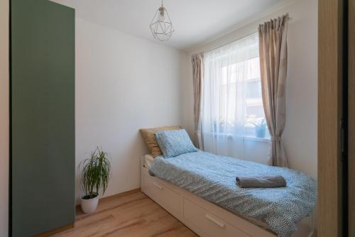 a bedroom with a bed and a window at Captain’s Home Kenese Apartman in Balatonkenese