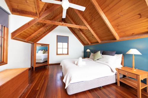 ein Schlafzimmer mit einem weißen Bett und einer Holzdecke in der Unterkunft Hidden Haven Barrington Tops in Cobark