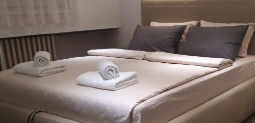 Una cama blanca con toallas encima. en 5 STAR CENTRAL STUDIO, en Skopje