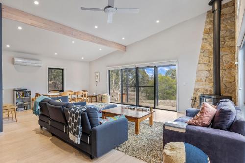 a living room with two couches and a fireplace at Benny's Retreat Luxury Bushland Escape in Clare