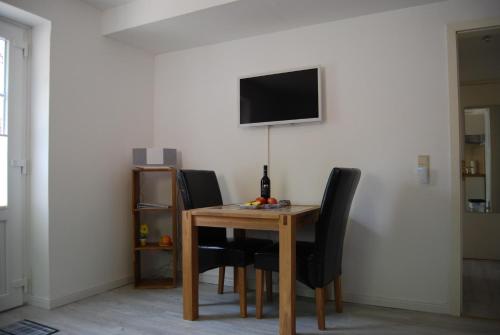 a dining room table with chairs and a television on a wall at Hinter Dem Schloss in Schleswig