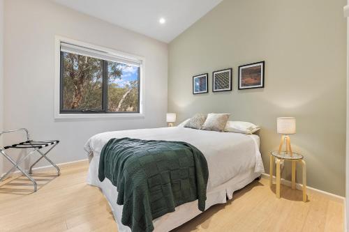 a bedroom with a large bed and a window at Benny's Retreat Luxury Bushland Escape in Clare
