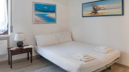 a small bedroom with a bed with towels on it at Welcomely - Costa 7A in Alghero