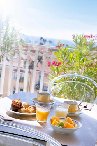 a table with plates of food and glasses of orange juice at Hotel Torino Wellness & Spa in Diano Marina