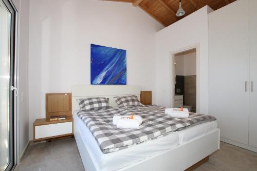 a bedroom with a bed with two pillows on it at Sunset Sea View Villa 2 in Agios Georgios