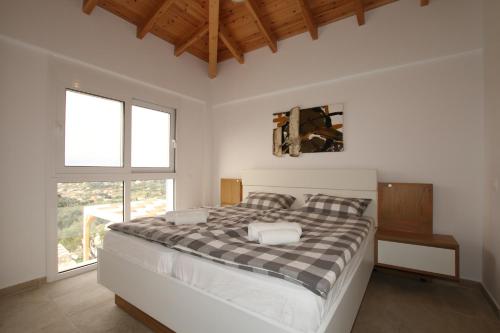 a bedroom with a bed with a checkered blanket at Sunset Sea View Villa 5 in Arillas