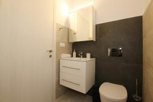 a bathroom with a white toilet and a sink at Sunset Sea View Villa 2 in Agios Georgios