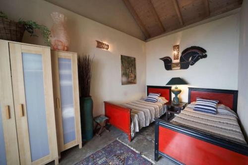 two beds in a room with red and white at Casa Buenavida in Alajeró