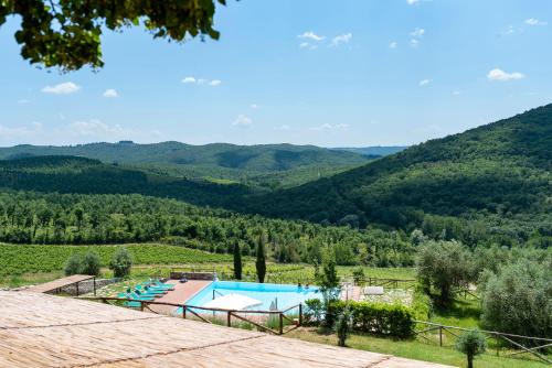 a resort with a swimming pool and mountains in the background at Castello Di Meleto in Gaiole in Chianti