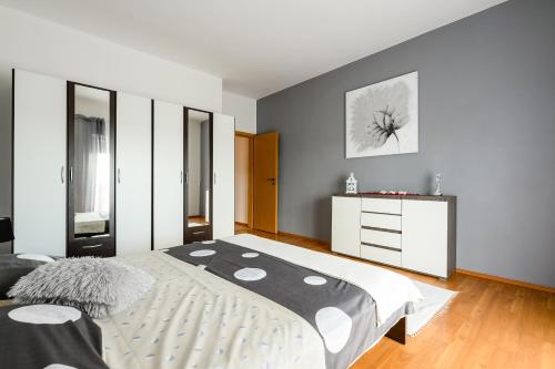 a bedroom with a large bed and a white dresser at Apartments Anita in Bibinje