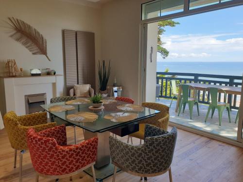 une salle à manger avec une table et des chaises et un balcon dans l'établissement Les Cigales, à La Baule