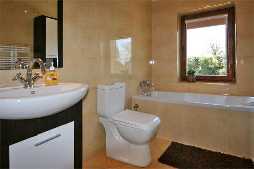 a bathroom with a sink and a toilet and a tub at Leniuchowo in Junoszyno