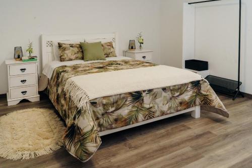 a bedroom with a bed and two night stands at Casa da Ribeira do Além in Angra do Heroísmo