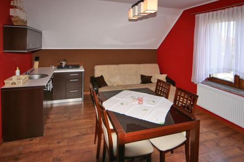 a living room with a table and a kitchen at Leniuchowo in Junoszyno