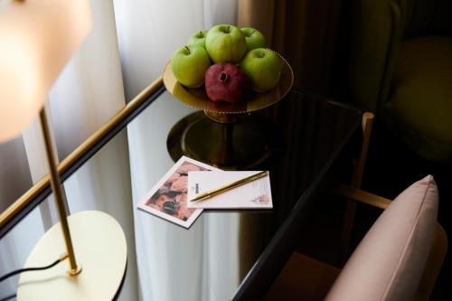 a table topped with a basket filled with fruit at Villa Brown Ermou Hotel, a member of Brown Hotels in Athens