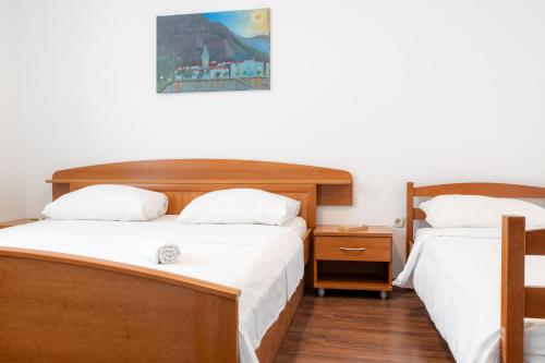 sypialnia z 2 łóżkami i zdjęciem na ścianie w obiekcie Apartman Glavina w Makarskiej