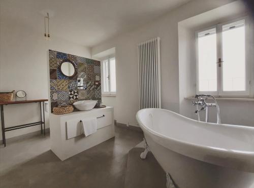 a white bathroom with a tub and a sink at La casa di Montegiardino in San Marino