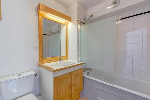 a bathroom with a sink and a toilet and a mirror at Les Valmonts 403 in Les Menuires