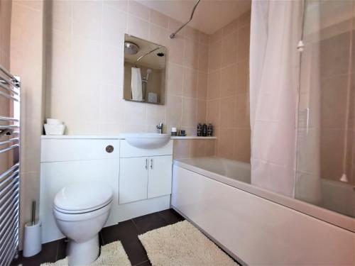 a bathroom with a toilet and a tub and a sink at Wellstone Cottages - Honeysuckle in Llanfyrnach