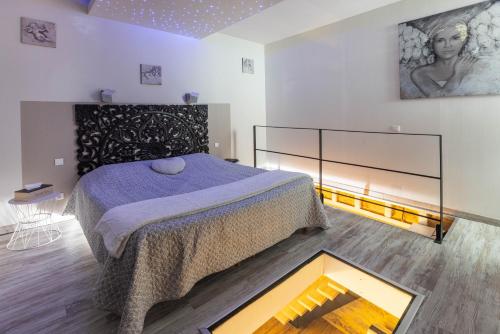 a bedroom with a bed and a painting on the wall at Au domaine des anges, 3 gîtes luxueux avec Jacuzzi privatif, sauna, mini-piscine, piscine extérieure chauffée en saison in Bain-de-Bretagne
