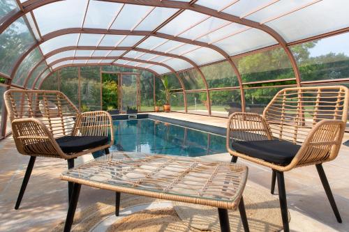 a patio with three chairs and a pool at Maison de Jean in Saint-Androny