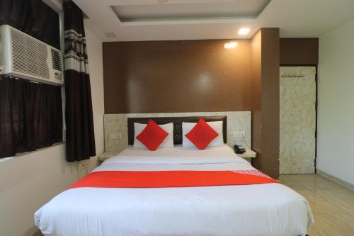 a bedroom with a large bed with red pillows at Hotel Airlift at Delhi Airport in New Delhi