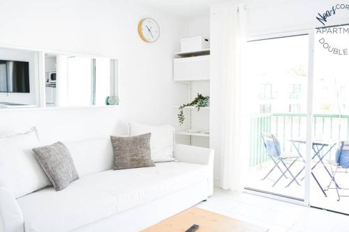 sala de estar blanca con sofá blanco y ventana en Sunny Noa's apartment double pool view- wifi fibra by Rentalfue, en Corralejo