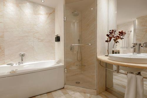 a bathroom with a tub and a sink and a shower at Melia Athens in Athens