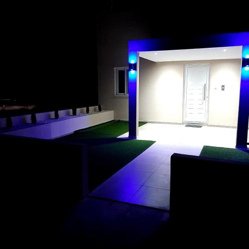 um quarto escuro com luzes azuis e uma porta em Universe House em Mor Menekshe