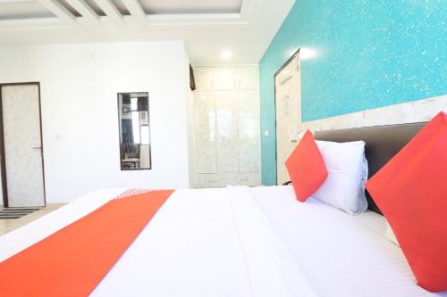 a bedroom with a large bed with red pillows at Hotel Airlift at Delhi Airport in New Delhi