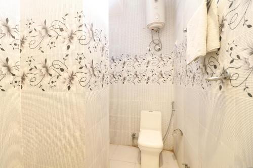 a white bathroom with a shower and a toilet at Hotel Airlift at Delhi Airport in New Delhi