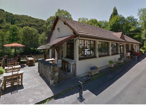 a restaurant with tables and chairs and a building at Hotel Restaurant Les Gorges de Chouvigny in Chouvigny