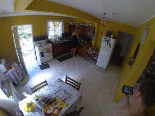 a man taking a picture of a kitchen with a table at Tina's Guest House in Ocho Rios