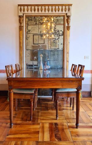 a dining room table with chairs and a large mirror at Castello di Lispida in Monselice