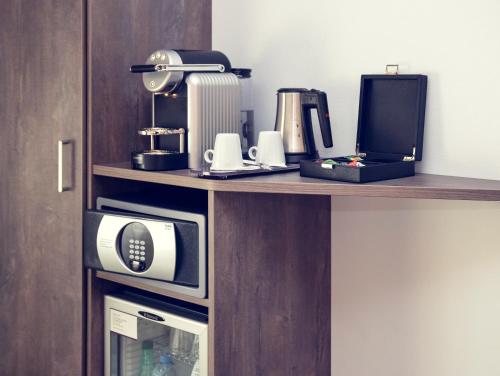 a room with a counter with a microwave at Mercure Lyon Est Chaponnay in Chaponnay