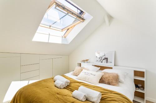 een slaapkamer met een groot bed en een dakraam bij Maison Sévigné - Le calme du Thabor et la proximité du centre ville in Rennes