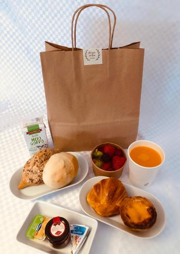 een tafel met een papieren zak en een bord met eten bij Belomont6 Apartments in Porto