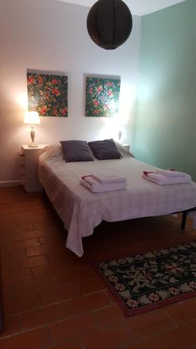 a bedroom with a bed with two towels on it at apartamento cinco reis in Angra do Heroísmo