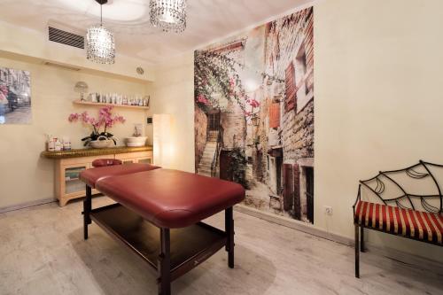 a living room with a bench and a painting on the wall at Hotel Pegaz in Krynica Zdrój