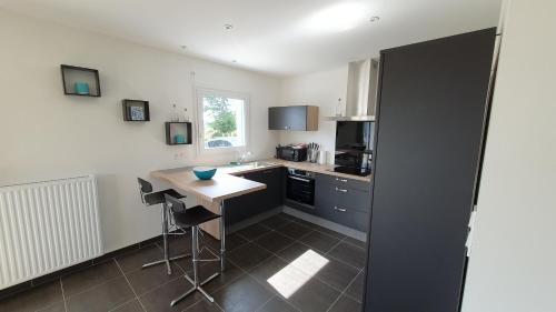 a kitchen with a counter and a table in it at Gîte des Hauts de Saint Jean in Saint-Jean-du-Doigt