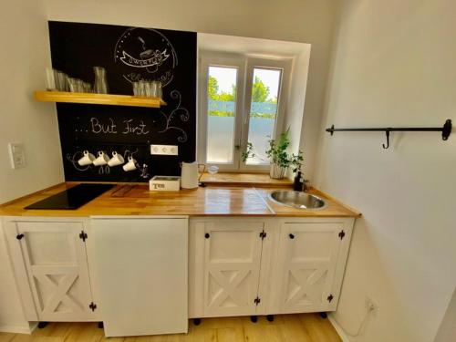 a kitchen with a counter with a sink and a window at Bíborlak in Villány