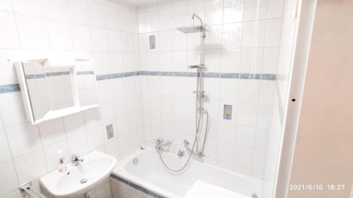 uma casa de banho branca com um chuveiro e um lavatório. em SUNNYHOME Monteurwohnungen und Apartments in Regensburg em Lappersdorf