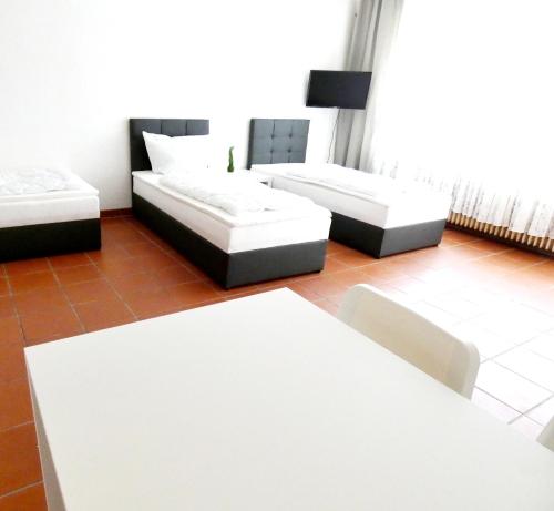 uma sala de estar com dois sofás brancos e uma mesa em SUNNYHOME Monteurwohnungen und Apartments in Regensburg em Lappersdorf