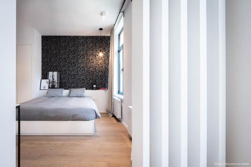 um quarto com uma cama e uma parede em preto e branco em Bedrooms fully equipped in a beautiful house em Bruxelas